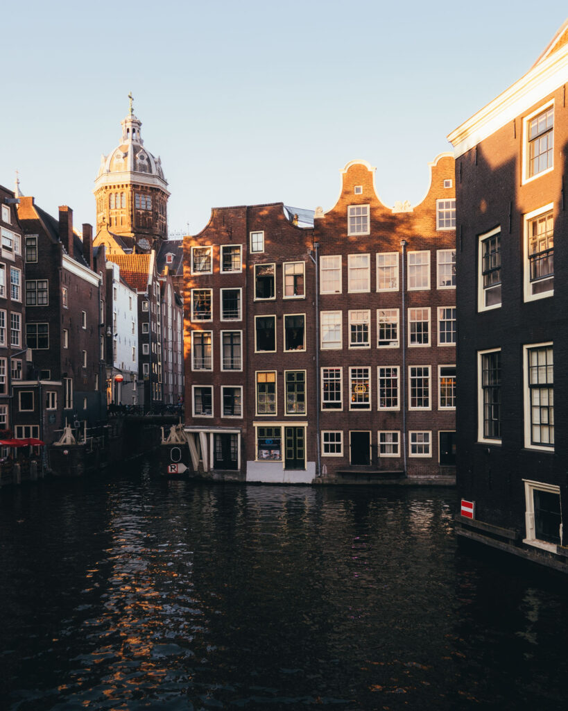 Amsterdam houses directly in canal with chapel (church) in the background