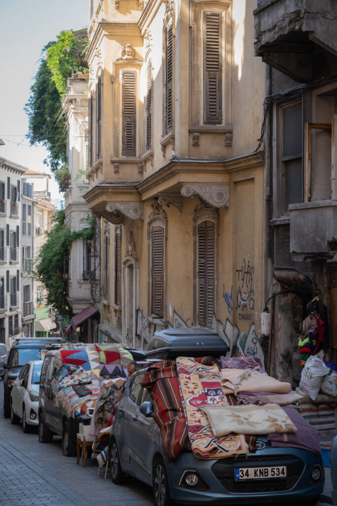 People selling carpets on top of cars in Çukurcuma