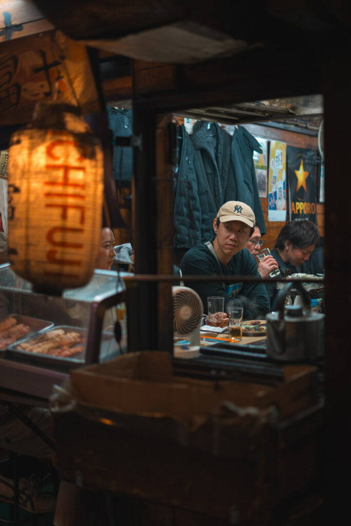 A person eating in a small restaurant in Omoide Yokocho