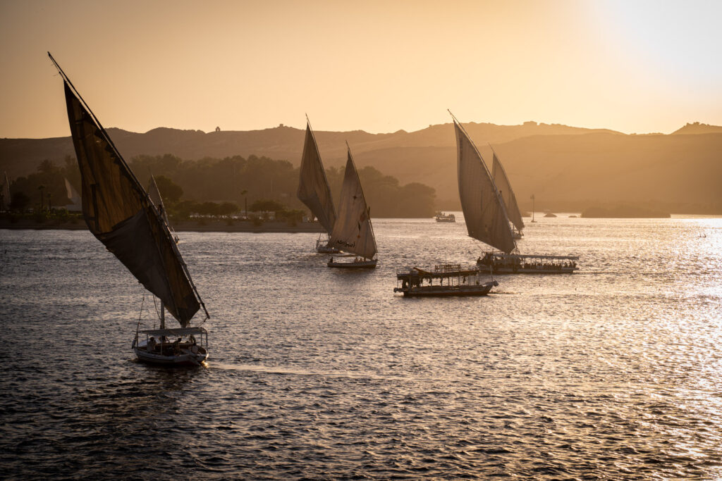Traditional Dahabiya Boats sailing the nile In Aswan during Sunset