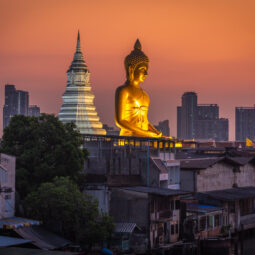 Wat Paknam Phasi Charoen golden buddha as seen from overpass during blue hour with orange sky.