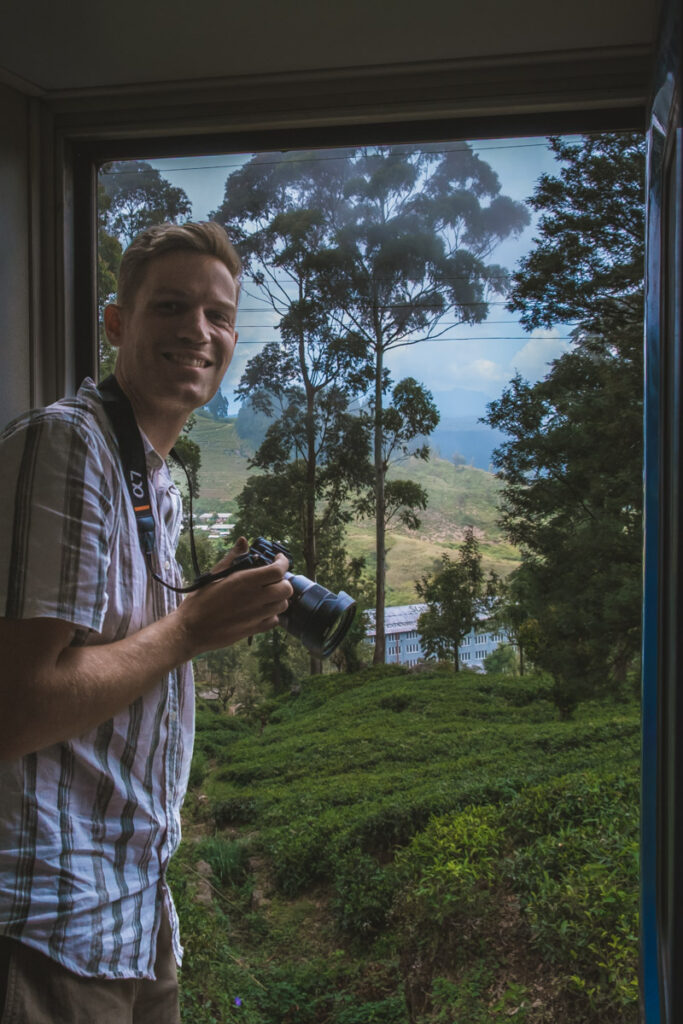 Michiel in the open train door frame on the railway journey from Kandy to Ella