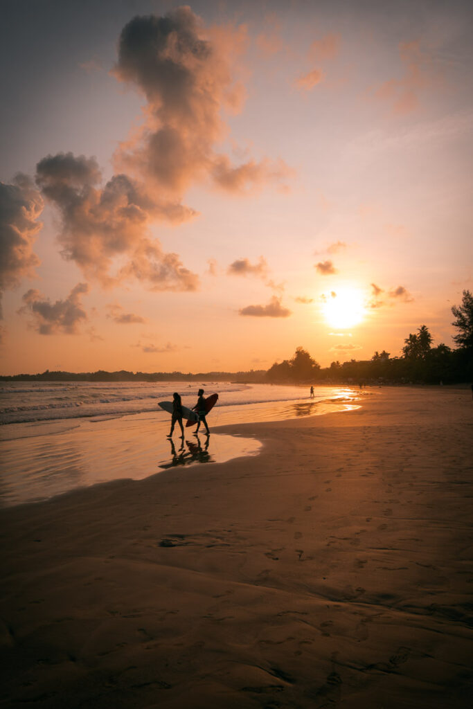 Surfers at Weligama beach during sunset